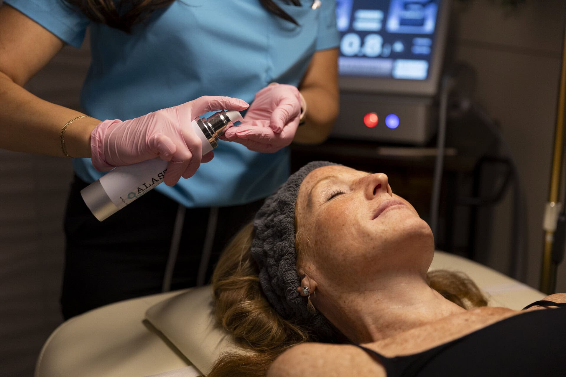 Medical professional administering nasal spray treatment to a woman at wellness clinic, focusing on ketamine therapy, pain relief, anxiety, depression, and holistic wellness services.