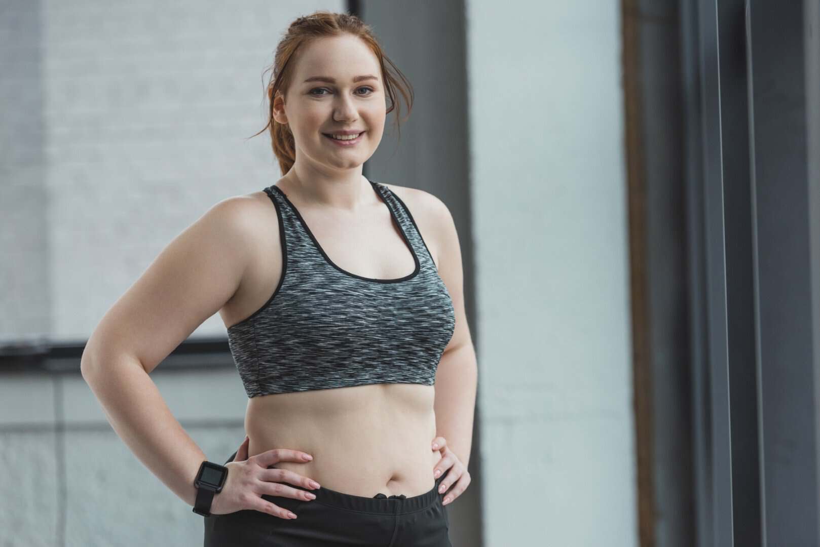 Smiling woman in workout attire at Wellness Drip Holyoke, showcasing confidence in non-invasive fat reduction treatments like HIFU and CoolSculpting. Non‑Invasive Fat Reduction for women