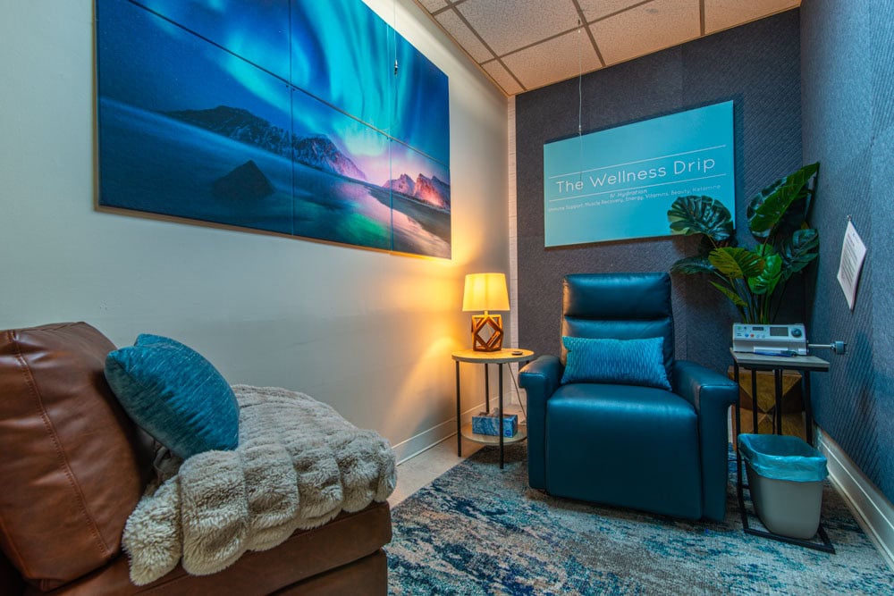 Relaxing wellness therapy room at The Wellness Drip INC with comfortable seating and light therapy equipment for IV vitamin infusions and ketamine therapy.