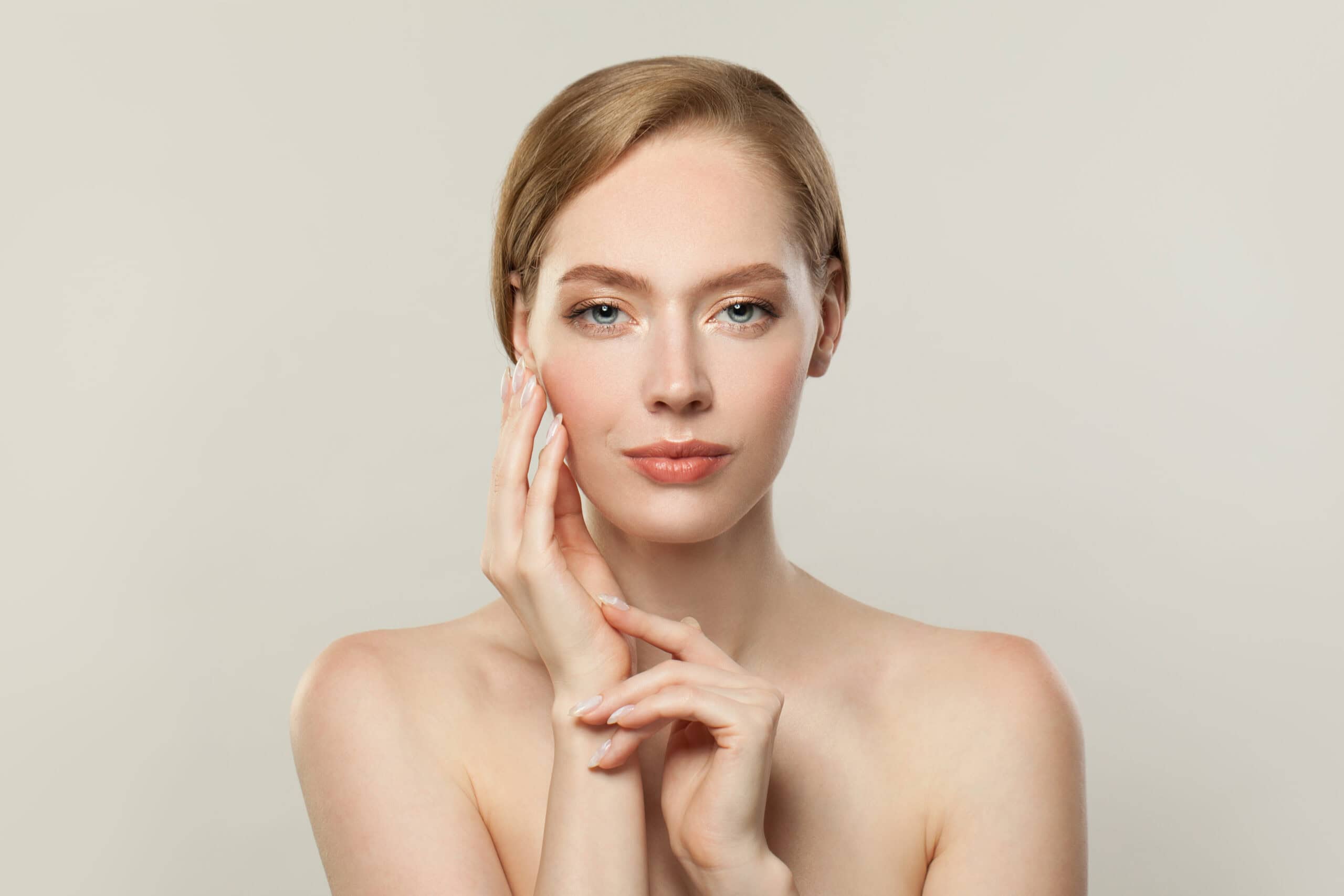 Beautiful woman with clear skin and natural makeup, promoting wellness and skincare services.