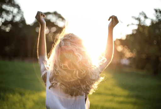 Healthy woman enjoying outdoor wellness and relaxation in a park, emphasizing holistic health and vitality services offered by The Wellness Drip INC.