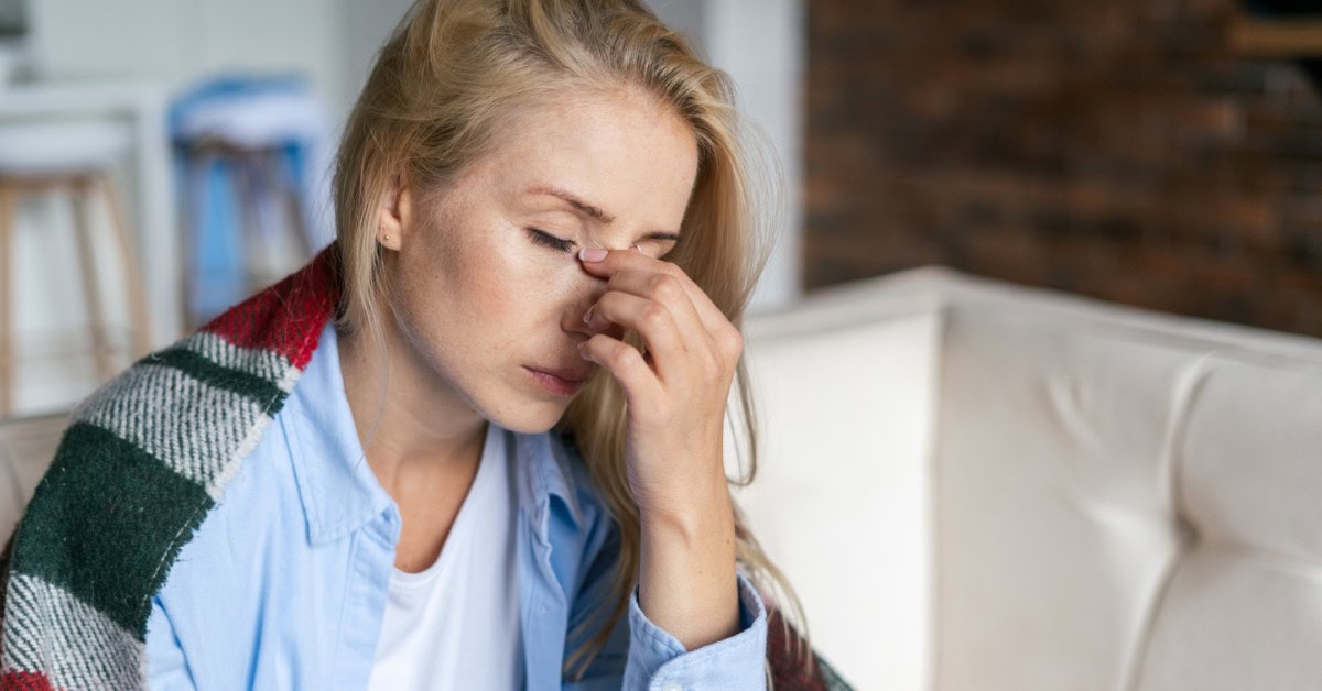 Headache relief woman holding forehead in discomfort at wellness clinic.