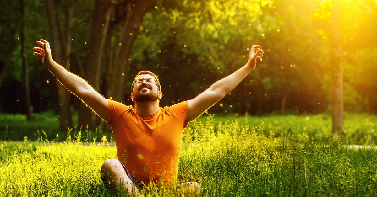 Relaxed man enjoying sunshine in a scenic park, emphasizing wellness, mental health, and natural healing services offered by The Wellness Drip INC in MA.