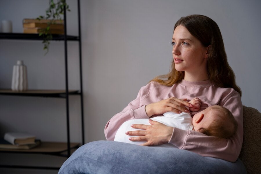 Serene woman breastfeeding her baby in a cozy home setting, promoting wellness and maternal health at The Wellness Drip INC in MA.