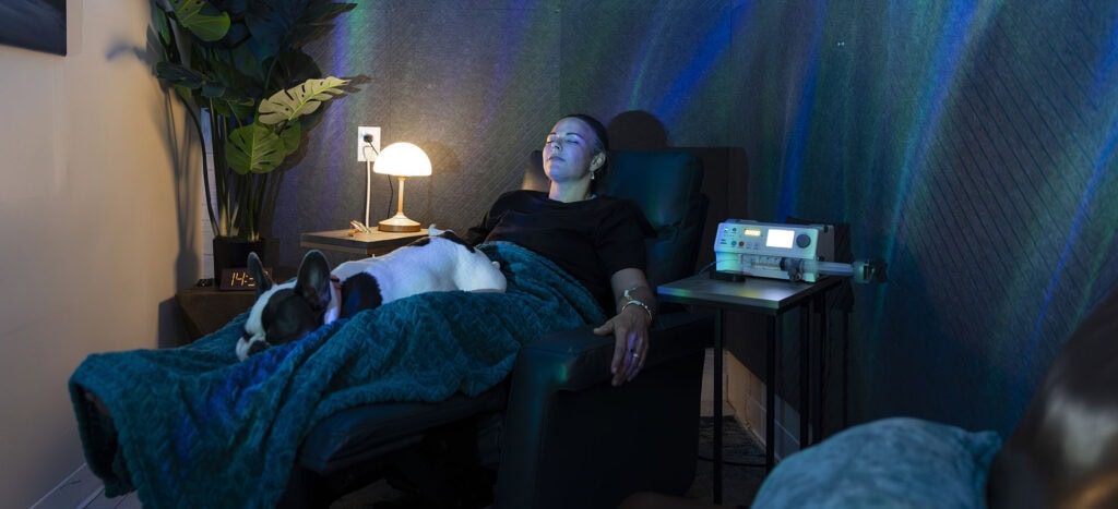 Relaxing woman receiving IV therapy and Ketamine treatment at wellness clinic for pain relief and mental health support.