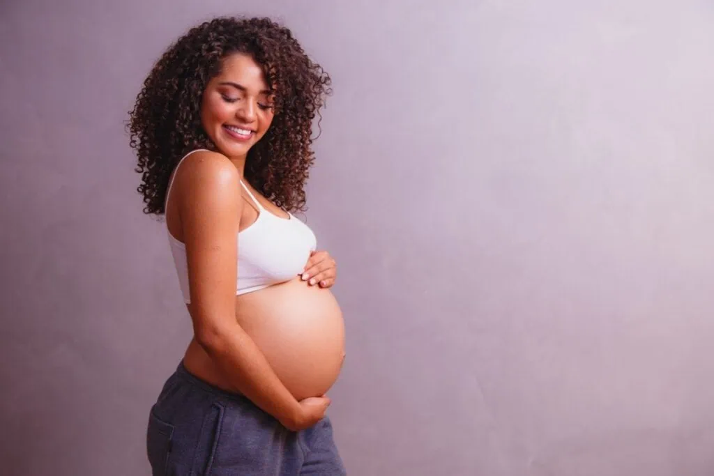 Pregnant woman holding her belly, promoting maternity wellness and hydration IV therapy at The Wellness Drip INC.
