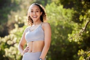 Happy young woman outdoors enjoying the benefits of intravenous vitamin therapy for improved health and wellness, promoting energy and immune support.
